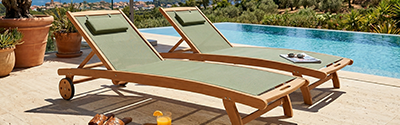 Neigbare Holz-Sonnenliegen mit Rädern in Salbeigrün am Rand eines schönen Pools